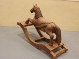 a wooden rocking horse that is on display in a room