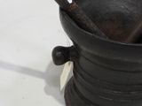a black metal cup with a handle and a tag on it