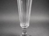 a clear glass vase with a black base and a gold rim