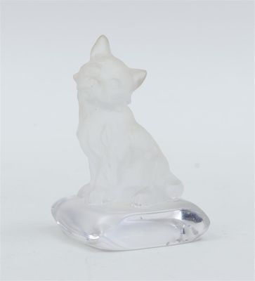 une figurine de chat blanc posée sur un socle transparent