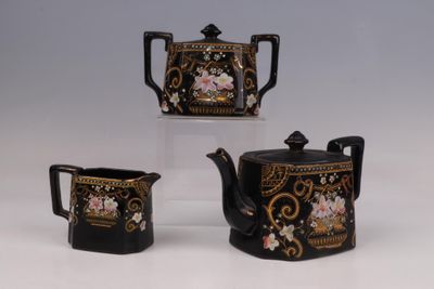 trois théières ornées de motifs noirs et dorés, posées sur un fond blanc