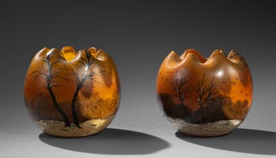 deux vases marron ornés d'arbres, posés sur une table