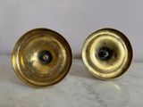pair of brass candlesticks on marble table with white background