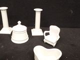 four pieces of white pottery sitting on a black surface