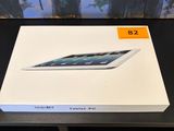 Un iPad d'Apple est posé sur une table devant un tableau