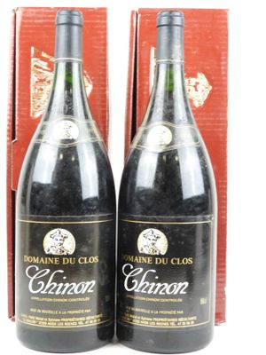 deux bouteilles de vin posées l'une à côté de l'autre devant une boîte rouge
