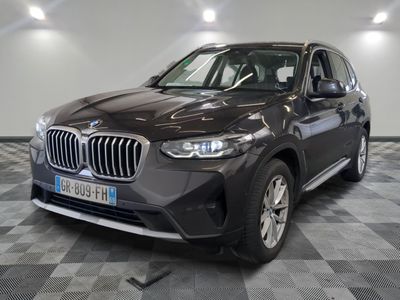 the bmw x1 is parked in a large room with a checkered floor