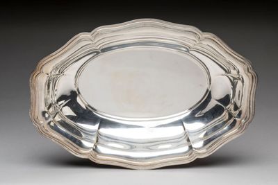 silver plate with scalloped edge on grey background