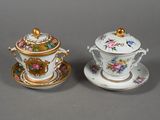 pair of porcelain tea cups and saucers decorated with floral designs