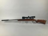 a rifle with a scope on a white background