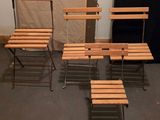 quatre chaises en bois et une table dans une pièce avec un mur