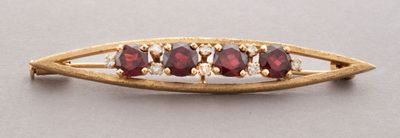 a close up of a gold broochle with garnets on it