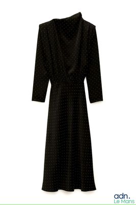 La robe est noire et est parsemée de pois.