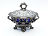 an antique silver and blue glass covered dish on a stand