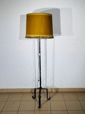floor lamp in a room with a yellow shade on top of it