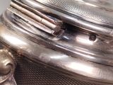 a close up of a silver tea pot on a table