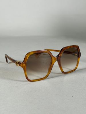 lunettes de soleil marron avec des verres marron sur un fond blanc
