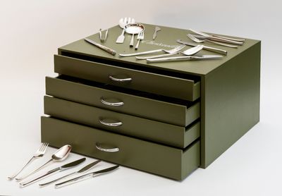 une boîte verte sur laquelle sont posés des couverts