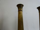 two tall gold vases sitting on a table