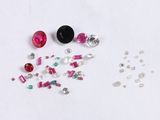 Plusieurs pierres de différentes couleurs sont dispersées sur une surface blanche