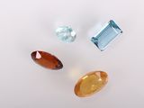 trois pierres précieuses de couleurs différentes posées sur une surface blanche
