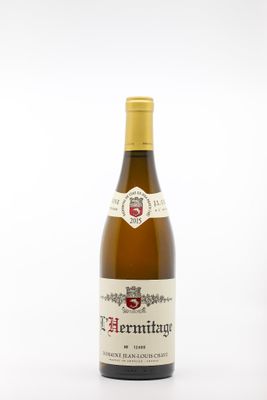 the bottle of white wine is sitting on a white surface