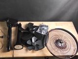 une table sur laquelle se trouvent un ventilateur, un sèche-cheveux et d'autres objets