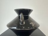 a black vase sitting on top of a black table