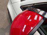 a close up of a red helmet on a white car