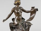 une image représentant une statue en bronze d'une femme assise sur un rocher