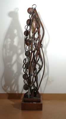 a sculpture made of metal on a wooden stand