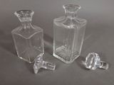 two clear glass bottles sitting next to each other on a table