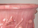a pink vase with a design on it on a table
