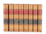 six vieux livres alignés sur une surface blanche