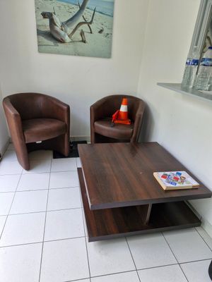 deux chaises et une table basse dans un coin d'une salle d'attente