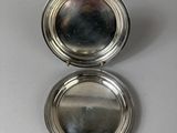 silver plated pill case with mirror on a white surface