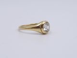 a yellow gold ring with a diamond on top