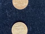 deux pièces d'or posées l'une à côté de l'autre sur une surface noire