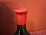une bouteille de vin posée sur une table à côté d'un mur