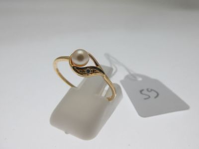 une image représentant une bague en or sertie d'une perle et d'un diamant