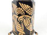 un vase noir et doré orné d'un motif représentant un oiseau