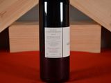 a bottle of red wine sitting on a red cloth