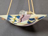 a ceramic bird hanging from a rope with coins in it