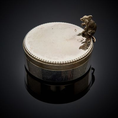 une boîte en argent surmontée d'un oiseau