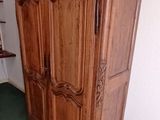a wooden armoire in the corner of a room