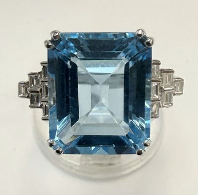 gros plan d'une bague avec une topaze bleue entourée de diamants
