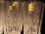 four glasses are lined up on a table with a black background