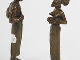 pair of bronze figurines of a woman and a man holding a basket
