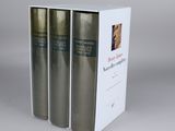 three books in a white box on a gray surface