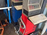 un ordinateur et un clavier posés sur un chariot dans un garage